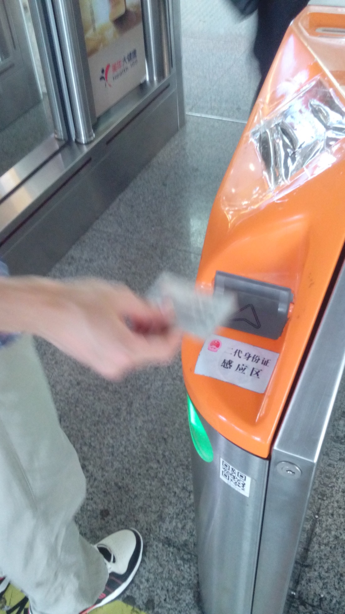 A passenger tapping a Chinese resident identity card at a high-speed rail gate in Shenzhen North Railway Station